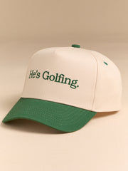 He's Golfing Trucker Hat