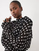 Noughts & Kisses Chiffon High Neck Shoulder Pad Blouson Mini Dress In Black Polka Dot